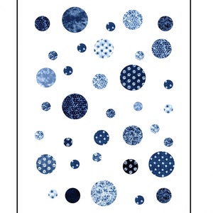May include: A quilt pattern called "Giggles" by Debbie Maddy of Tiori Designs. The pattern features a white background with blue circles of various sizes and patterns. The pattern is layer cake friendly and can be made in two sizes: 57 inches by 76 inches or 63 inches by 63 inches.