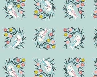May include: A repeating pattern of white birds with blue and pink accents, each surrounded by a wreath of green leaves, pink and yellow flowers, and small blue dots, set against a light blue background.