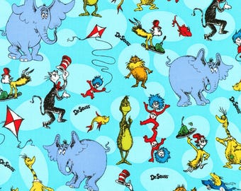May include: A light blue fabric featuring a repeating pattern of Dr. Seuss characters including Horton the elephant, The Cat in the Hat, Thing One and Thing Two, the Lorax, and red and white kites, with the text Dr. Seuss printed throughout the design.