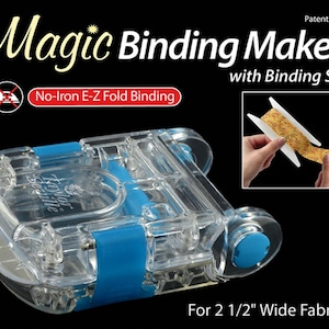 May include: A clear plastic Magic Binding Maker tool with blue accents, designed for 2 1/2 inch wide fabric. The device features a No-Iron E-Z Fold Binding label and includes a small inset image showing a floral fabric strip on a white spool.