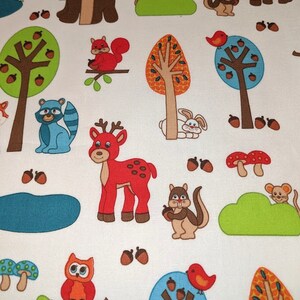 May include: A white fabric with a repeating pattern of woodland animals and trees. The animals include a bear, deer, squirrel, owl, rabbit, mouse, and bird. The trees are green, orange, and blue. There are also mushrooms and acorns in the pattern.