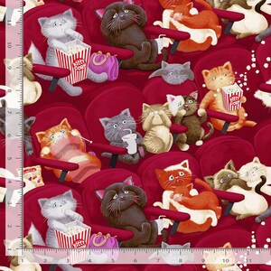 May include: A repeating pattern of cartoon cats in a movie theater setting. The cats are various colors and are seated in red theater chairs, some holding popcorn and drinks. The text "Kitty Korn" is visible on a popcorn container.