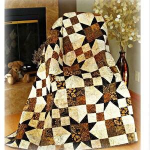 May include: A quilt pattern titled "Simply Elegant" with a star and square design in shades of brown, black, and cream. The twin size is 60" x 84", queen is 84" x 108", and king is 108" x 108". The Pleasant Valley Creations logo is at the top.