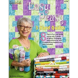 May include: A woman in a green shirt holds fabric rolls and a stack of quilts. The book cover reads "Easy Peasy 3-Yard Quilts" with the text "8 Fast & Fun Lap Quilts using only 3 yards of fabric!" and the Fabric Cafe logo.
