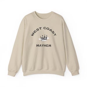Peut inclure: Un sweat-shirt beige à manches longues. Le devant présente le texte "WEST COAST MAYHEM" en noir, arqué au-dessus d'un motif de couronne. Le sweat-shirt est de style décontracté, adapté au quotidien.