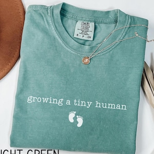 Koszulka Growing A Tiny Human, Koszulka Comfort Colors® w ciąży, Prezent dla przyszłej mamy, Koszulka z informacją o ciąży, Prezent na baby shower, Ujawnienie dziecka