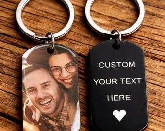 May include: Two metal keychains with silver rings. One keychain features a color photo of a smiling couple. The other is black with the words "CUSTOM YOUR TEXT HERE" and a white heart symbol.