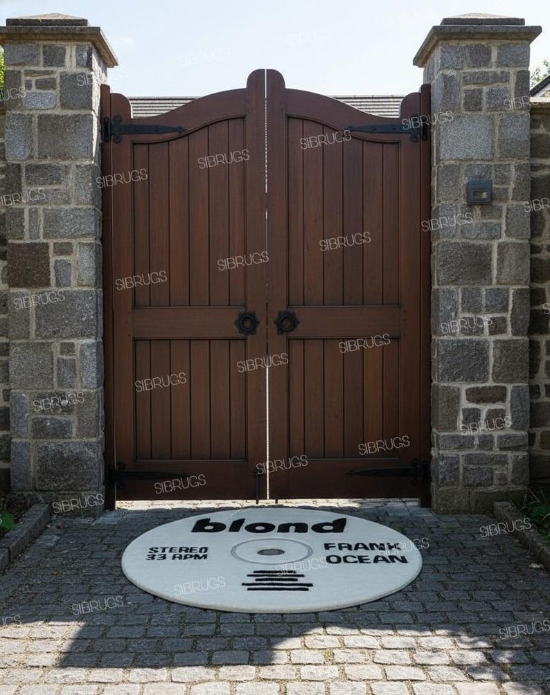 May include: A round, off-white rug with the text "blond FRANK OCEAN" in black, designed to resemble a vinyl record. The rug is placed in front of a dark wooden gate, flanked by stone pillars. The text "STEREO 33 RPM" is also visible.
