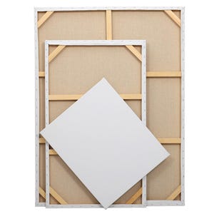 Puede incluir: Tres lienzos en blanco. Dos son rectangulares, uno grande y otro mediano, con lienzo blanco estirado sobre marcos de madera. Un tercer lienzo cuadrado, más pequeño, está apoyado contra los otros dos.