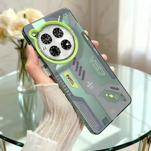 May include: A clear phone case with a green and gray camouflage design. The case features a circular camera cutout with a lime green ring and the text "V63" and "QIS".