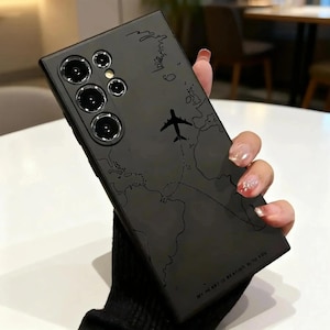 May include: Black phone case with a world map design and an airplane graphic. The case has a matte finish and features the text "MY HEART IS BEATING WITH YOU". The case is held by a person.