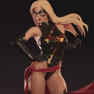 May include: A statue of a superheroine in a black bodysuit with a gold lightning bolt design. She wears a black mask, gloves, and boots, with a red sash and flowing blonde hair. The figure is posed with one hand on her hip.