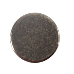 May include: A round, silver-toned metal button with a slightly textured surface.