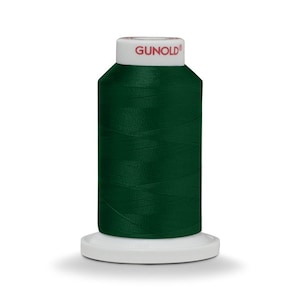 May include: A spool of dark green thread with the brand name "GUNOLD" printed on the label.