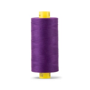 May include: A spool of purple thread with a yellow label that says "100% Polyester" and "100".