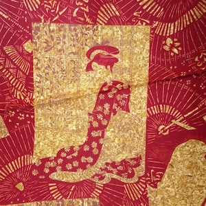 May include: Red fabric with a gold pattern of a Japanese woman in a kimono and fans. The fabric has a textured look.