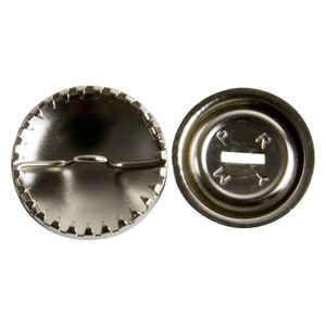 May include: A silver metal snap fastener with a serrated edge and a small metal loop. The back of the fastener has a small hole and the letters "P N T Y" printed on it.