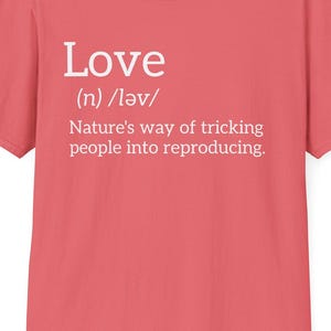 Può includere: Una maglietta color corallo con la parola "Love" in bianco, la sua pronuncia fonetica e una definizione umoristica: "Il modo in cui la natura inganna le persone per riprodursi."