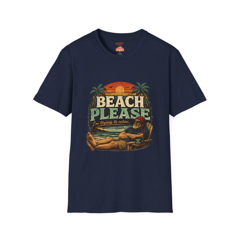 A navy blue t-shirt with a graphic design depicting a man relaxing on a beach, with the text "BEACH PLEASE I'M DYING TO RELAX" printed on it.