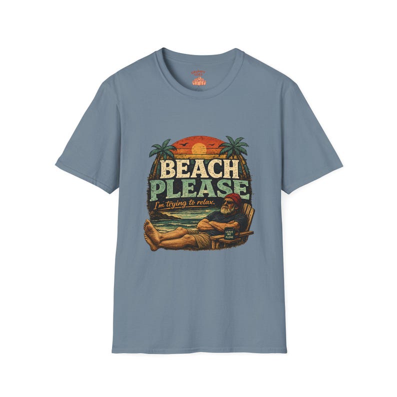 A t-shirt with a graphic design featuring a man relaxing on a beach chair with palm trees and a sunset in the background. The text on the t-shirt says "BEACH PLEASE I'M DYING TO RELAX".