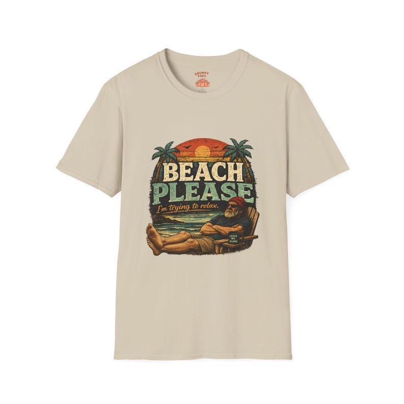 A t-shirt with a graphic design featuring a man relaxing on a beach with palm trees and a sunset in the background. The text on the t-shirt says "BEACH PLEASE I'M DYING TO RELAX".