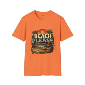 An orange t-shirt with a graphic design depicting a man relaxing on a beach with palm trees and a sunset in the background.