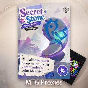 May include: A rectangular game card titled Secret Stone Arcane Signet Artifact featuring a glossy, iridescent purple and blue stone-like object with glowing blue markings. The card text reads: Add one mana of any color in your commander's color identity.