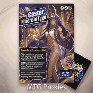 May include: A trading card featuring an illustration of a dark-skinned deity with long purple hair, wearing gold jewelry and a white and blue garment. The card displays the text Caster, Nitocris of Egypt, The Scarab God, and game rules.