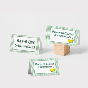 May include: Three white tent cards with green striped borders. Two cards read "Pimento Cheese Sandwiches" with a yellow map graphic. The third card reads "Bar-B-Que Sandwiches". One card is on a small wooden block.
