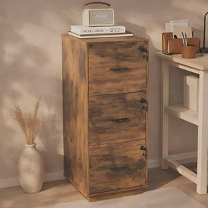 Puede incluir: Un archivador vertical de tres cajones con acabado de madera marrón rústica. Cada cajón cuenta con un tirador horizontal negro y una pequeña cerradura circular. Un altavoz blanco y un libro titulado Mchellation se encuentran en la superficie superior.