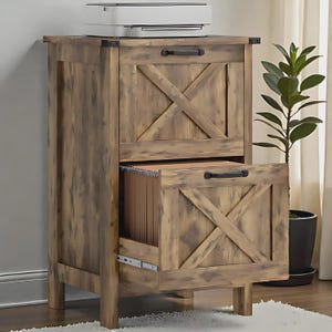 Puede incluir: Un archivador de madera de dos cajones con acabado marrón desgastado y herrajes de metal negro. Cada frente de cajón presenta un diseño decorativo en forma de X. El cajón inferior está entreabierto, mostrando carpetas colgantes.