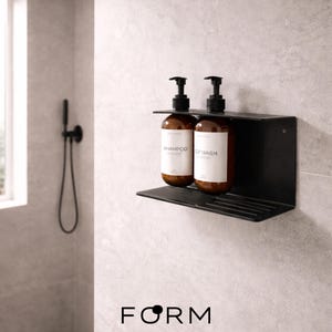 May include: A black metal shelf holding two brown bottles with black pump dispensers. The bottles are labelled "SHAMPOO" and "BODY WASH". The shelf is mounted on a light grey tiled wall. The word "FORM" is printed at the bottom.