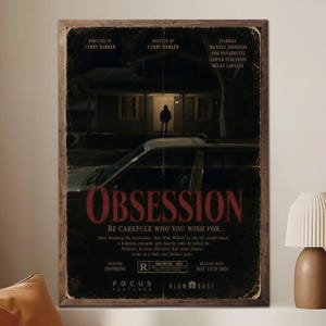 Puede incluir: Un póster de película enmarcado para "Obsession" con una estética vintage y desgastada. El póster presenta una casa por la noche, un coche y el título en letras rojas grandes. Incluye los nombres del director, escritor y actores.