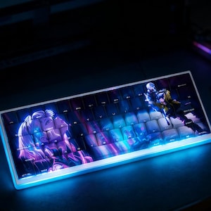 May include: A white mechanical keyboard with a custom design featuring anime-style artwork. The keycaps display a vibrant illustration with purple, blue, and pink hues. The keyboard has a glowing blue edge.