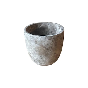 Puede incluir: Una maceta cilíndrica con una superficie texturizada y desgastada en tonos gris, beige y marrón. El recipiente presenta una parte superior ancha y abierta con una base redondeada, mostrando una apariencia moteada similar a la piedra natural.