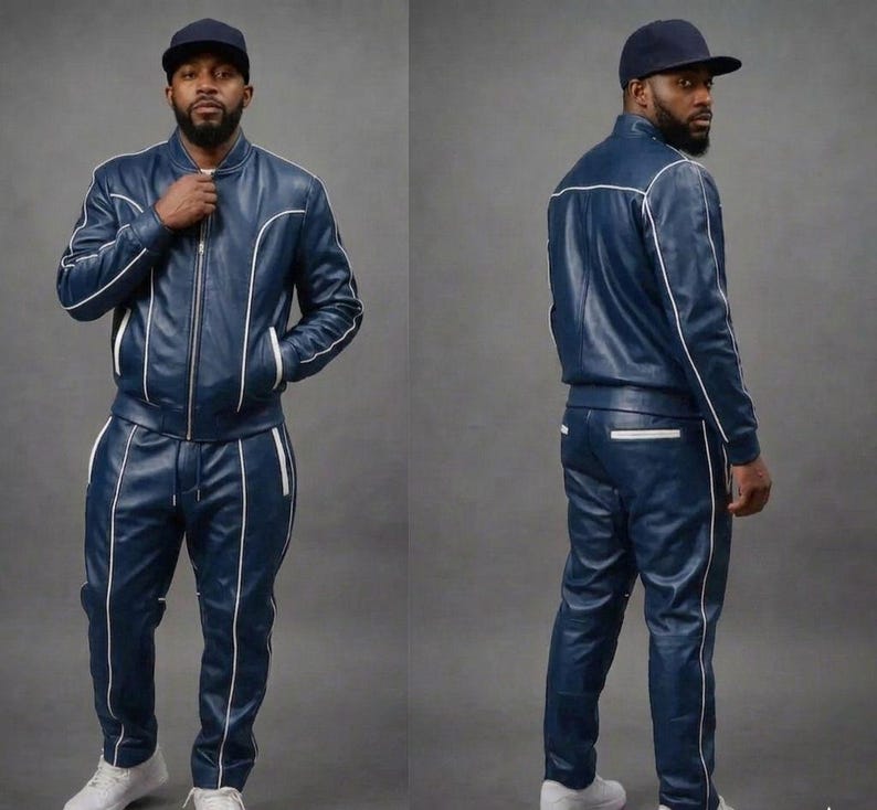 May include: A navy blue leather tracksuit with white piping. The jacket has a zip-up front and pockets. The pants have a drawstring waist and pockets. The person is wearing a navy blue baseball cap and white sneakers.