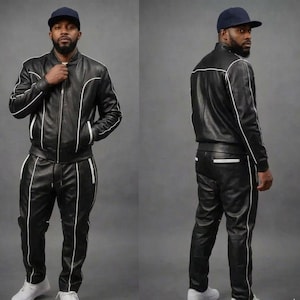 May include: A black leather tracksuit with white trim and a matching black baseball cap. The jacket is zipped up and the trousers have a drawstring. The outfit is worn with white trainers.