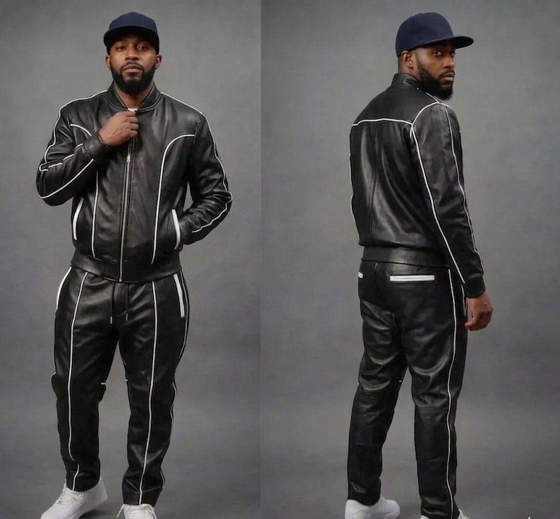 May include: A black leather tracksuit with white trim and a matching black baseball cap. The jacket is zipped up and the trousers have a drawstring. The outfit is worn with white trainers.