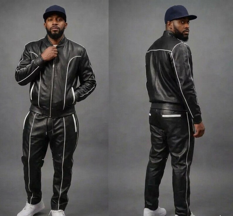 May include: A black leather tracksuit with white trim and a matching black baseball cap. The jacket is zipped and the trousers have a drawstring. The outfit is worn with white trainers.