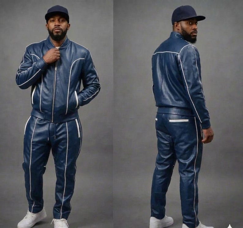 May include: A navy blue leather tracksuit with white trim. The jacket has a zip-up front and pockets. The pants have a drawstring waist and pockets. The person is wearing a navy blue baseball cap and white sneakers.