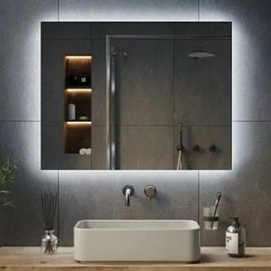 Puede incluir: Un espejo rectangular de baño con un borde LED blanco brillante. El espejo está montado sobre un lavabo rectangular blanco y una encimera de madera. El fondo presenta paredes de azulejos grises y una ducha.