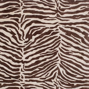 May include: A rug with a zebra stripe design, featuring alternating bands of brown and off-white. The pattern creates a striking visual effect. The rug's texture appears soft, making it suitable for home decor and adding a touch of the exotic.