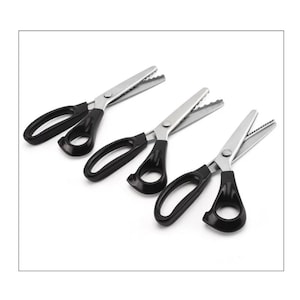 May include: Three pairs of silver and black scissors with serrated blades. The scissors have black handles with finger holes and are arranged diagonally on a white background. The blades are made of shiny metal.
