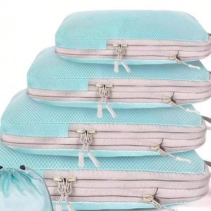 May include: A set of five turquoise packing cubes in varying sizes, stacked. Each cube has a gray zipper and trim, with a matching handle. A small drawstring bag is also included, all against a white background.