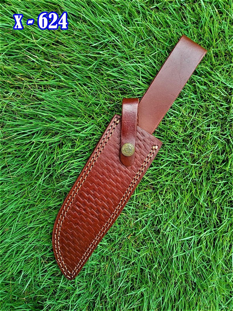 May include: A brown leather knife sheath with a woven texture and white stitching. The sheath has a brown leather belt loop and a button closure. The text "x - 624" is in the upper left corner.