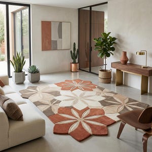 Puede incluir: Una gran alfombra con estampado floral en tonos óxido, beige y marrón domina la habitación. El diseño de la alfombra presenta grandes formas de flores estilizadas. La habitación también incluye un sofá, plantas y una consola de madera.