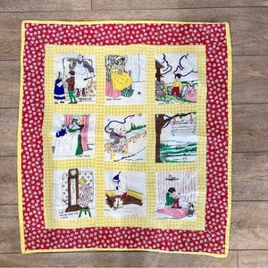 Puede incluir: Un edredón hecho a mano con nueve cuadrados ilustrados que representan escenas de rimas infantiles, incluyendo "Jack and Jill" y "Little Jack Horner". El edredón tiene un centro de cuadros amarillos, un borde floral rojo y un borde floral rojo.