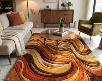 May include: A rectangular area rug featuring a textured, wavy pattern in shades of brown, orange, yellow, and cream. The rug has a high-pile, carved design that creates depth and movement across the surface. The text Ibrahim Art Rugs is visible.