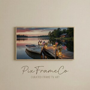 May include: A framed print of a lake scene at dusk. A white rowboat is tied to a wooden dock adorned with American flags, lanterns, and floral arrangements. The sky displays a vibrant sunset, and the text "Pix Frame Co" is visible.