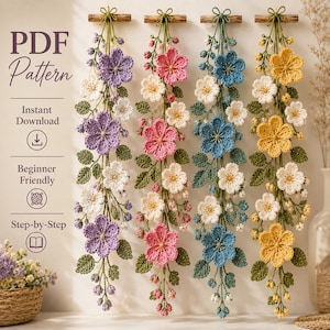 Puede incluir: Un patrón PDF para cuatro tapices de pared de ganchillo verticales con guirnaldas florales en morado, rosa, azul y amarillo. Cada tapiz incluye flores, capullos y hojas verdes de ganchillo suspendidos de un palo de madera.